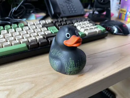 Photo of a rubber duck next to a keyboard